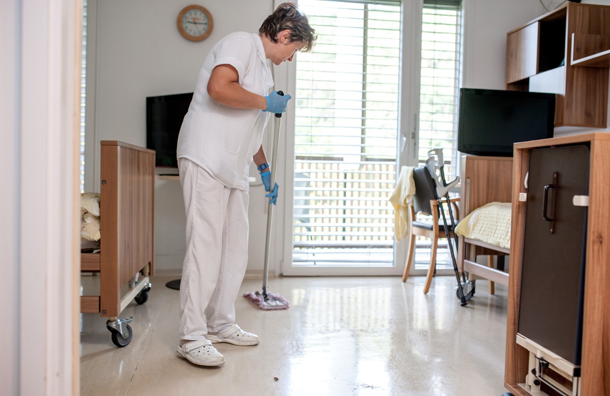 Schoonmaakster dweilt vloer in care_web Schoonmaakster dweilt vloer in care_web