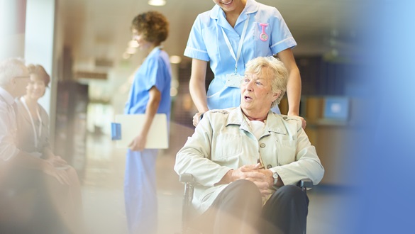 Verpleegkundige met dame in rolstoel